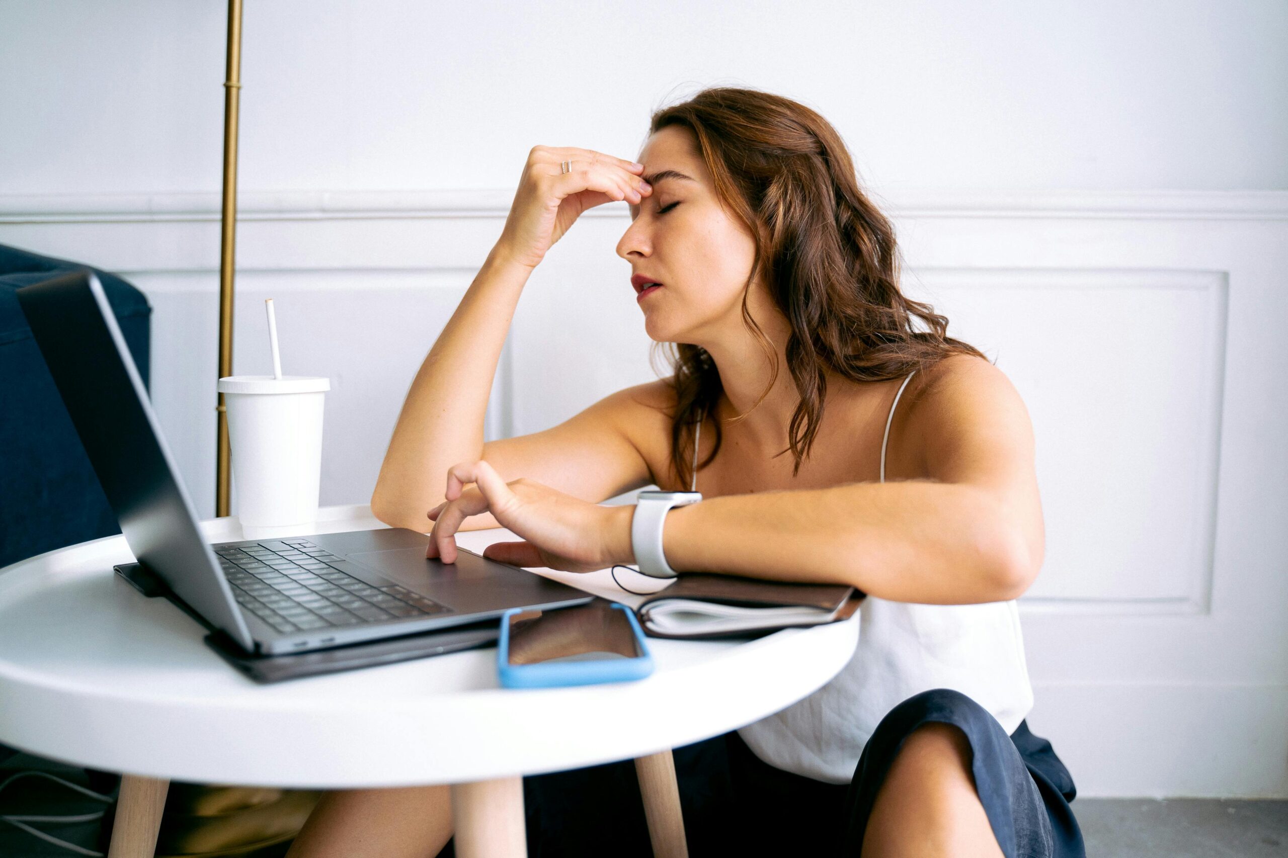 stressed woman at laptop sitting on floor