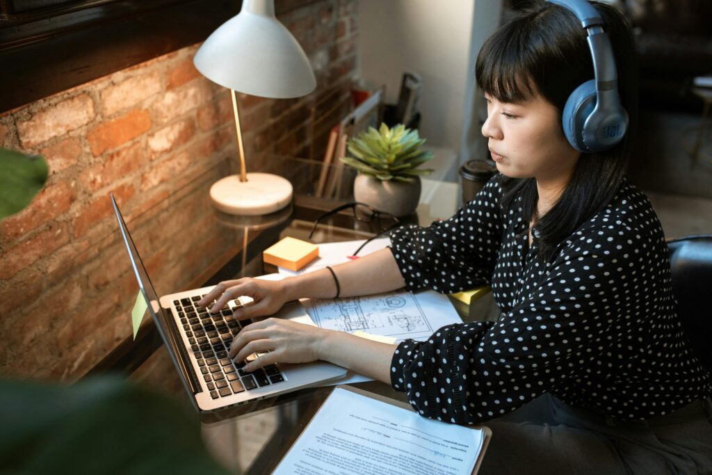 woman typing with headphones on